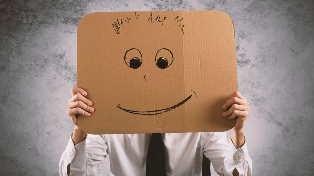 person holding cardboard smile sign