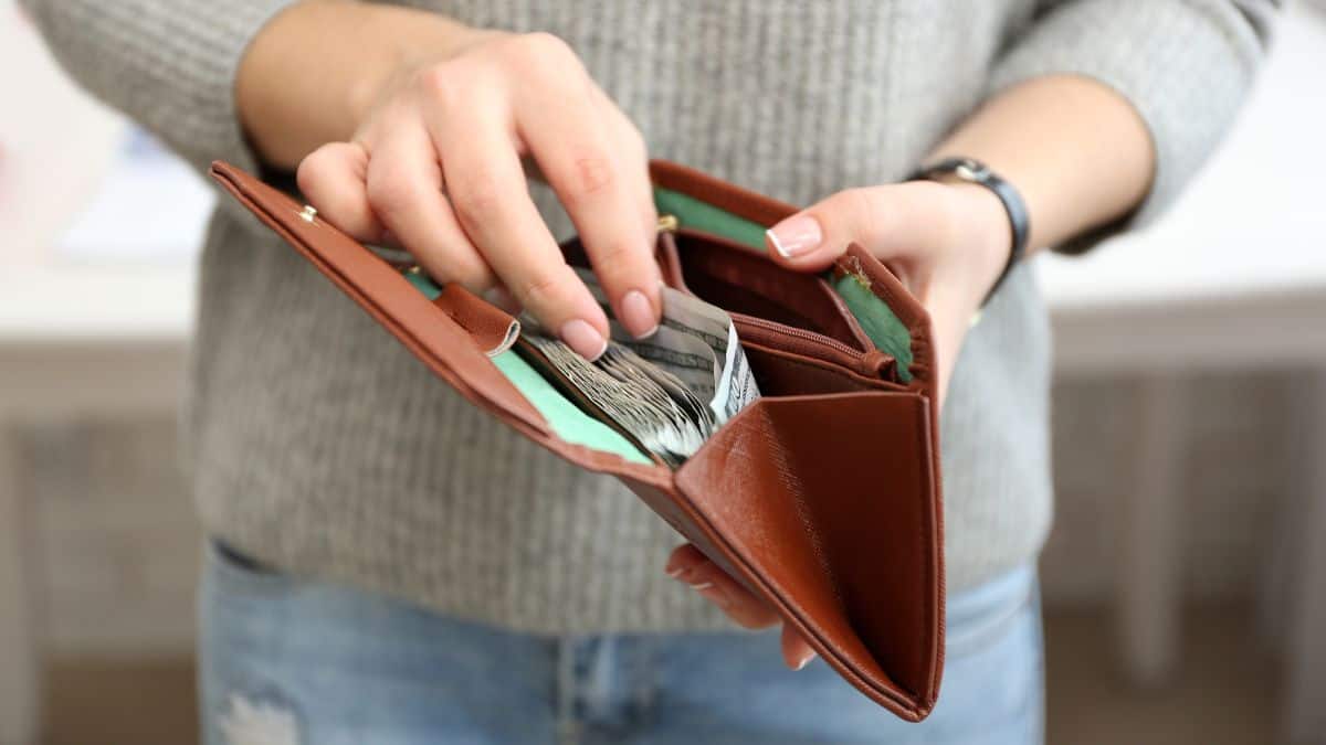 hands pulling money out of wallet